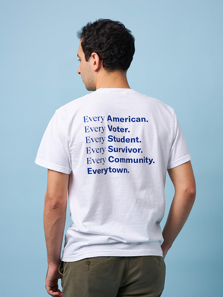 Back view of a man wearing a white unisex short sleeve t-shirt with large dark blue print that reads: Every American. Every Voter. Every Student. Every Survivor. Every Community. Everytown.