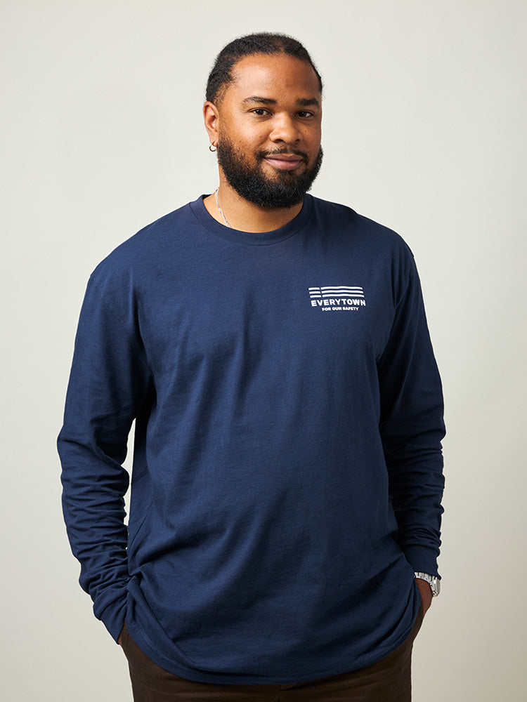 Man wearing a navy blue long sleeve unisex shirt with a small white Everytown for Gun Safety logo printed on left chest.
