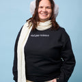 Front view of person wearing a black crewneck sweatshirt with the phrase end gun violence embroidered in white, all lowercase, in a serif font.