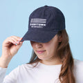 Person wearing a navy blue ballcap with a white Everytown for Gun Safety logo embroidered on the front.