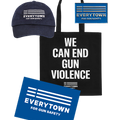 Product image of navy blue ballcap with white embroidered Everytown for Gun Safety logo on front, blue enamel pin with silver Everytown for Gun Safety logo, black tote bag with white, centered, uppercase text that reads: WE CAN END GUN VIOLENCE, with a small white Everytown logo below, and a 11 x 17 inch placard with white Everytown for Gun Safety logo on a blue background.
