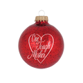 Red, glittery, round plastic ornament with One Tough Mother printed in script font in white on one side.