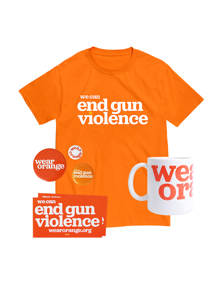 Orange short-sleeve unisex t-shirt, front view. In large white print across the chest, it reads: we can end gun violence. The dot of the i in violence is printed in light orange. Three round orange buttons of various sizes and 2 rectangular stickers that read: we can end gun violence wearorange.org. White ceramic mug with Wear Orange logo printed large in orange.