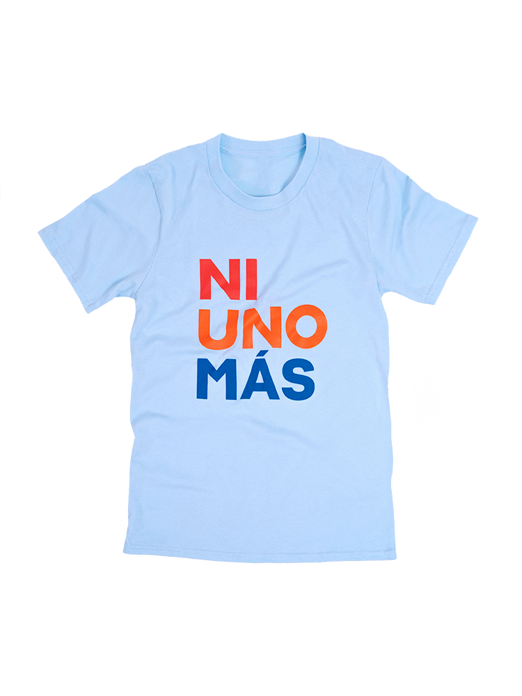 Front view of a light blue short sleeve unisex t-shirt with print that reads NI UNO MÁS in large, uppercase, red, orange, and blue letters.